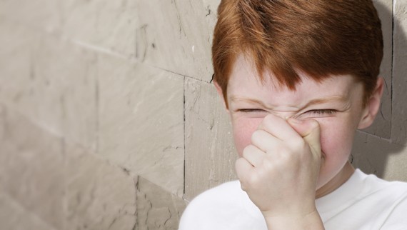 Jeune garçon se bouchant le nez