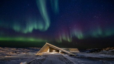 Das Eisfjordzentrum im spektakulären Nordlicht der grönländischen Polarnacht (© Adam Mørk)